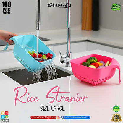 Blue large rice strainer draining berries over a sink with pink strainer nearby